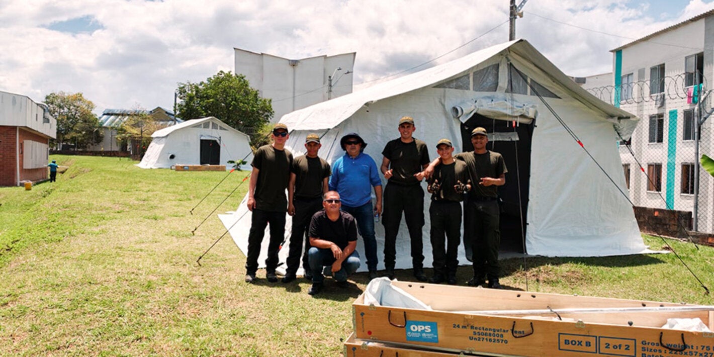 personas posando con una carpa detras