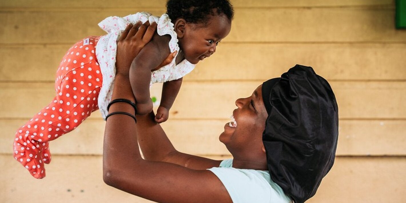 Madre alzando a su hija en suriname libre de malaria