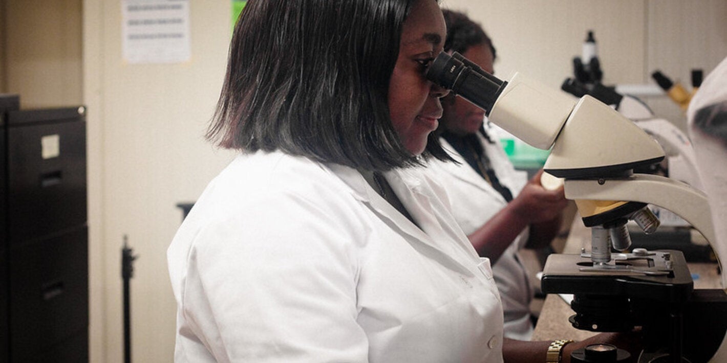 Bioquímica de Suriname observando en un microscopio