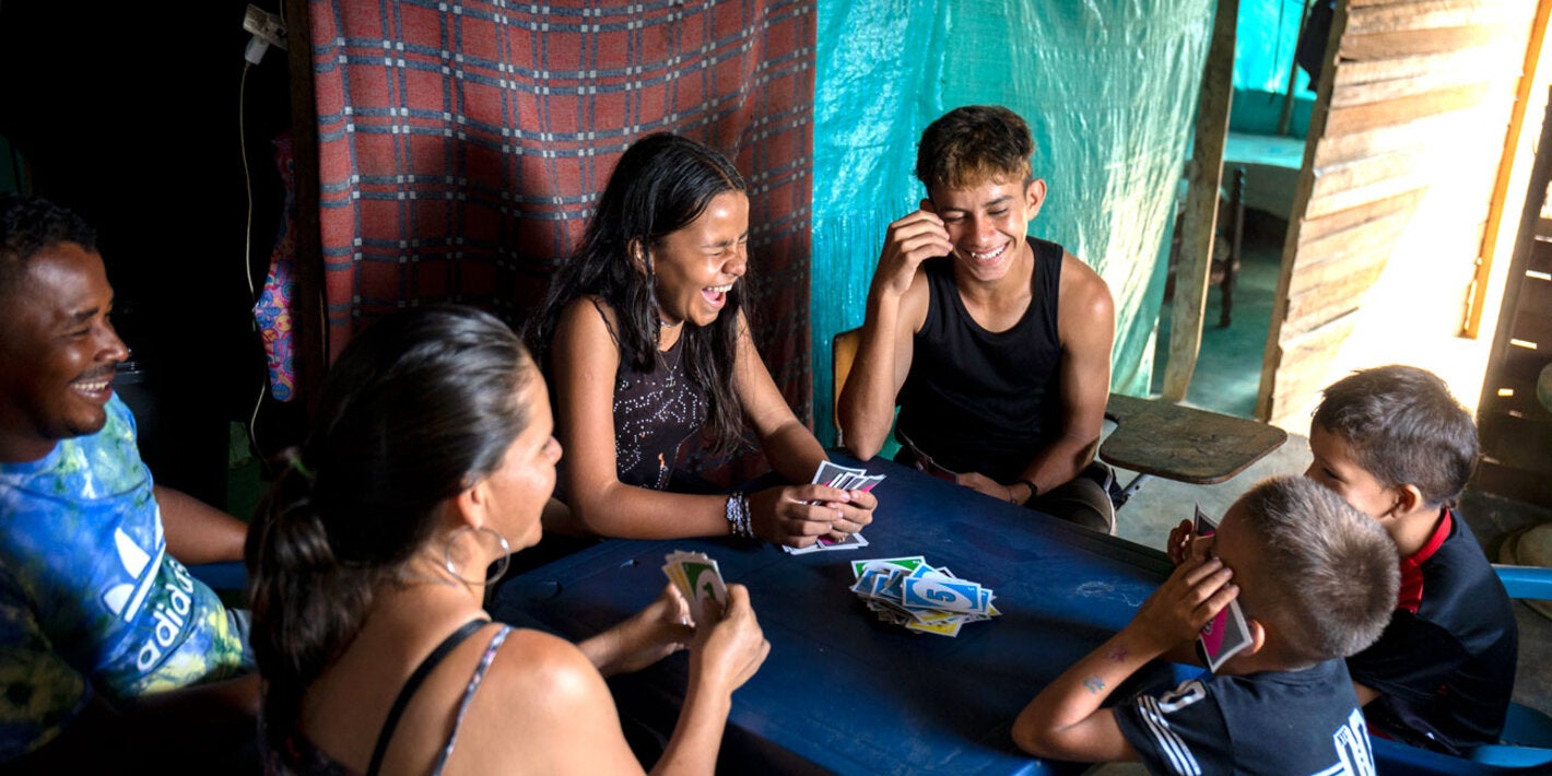 Una familia juega cartas: padres e hijos.