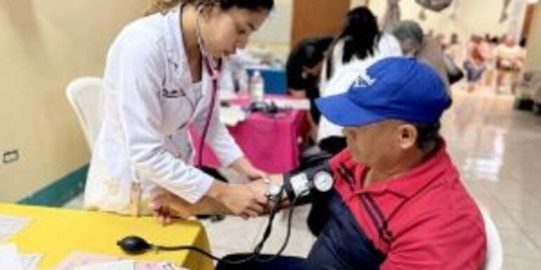 enfermera le toma la presión arterial a paciente