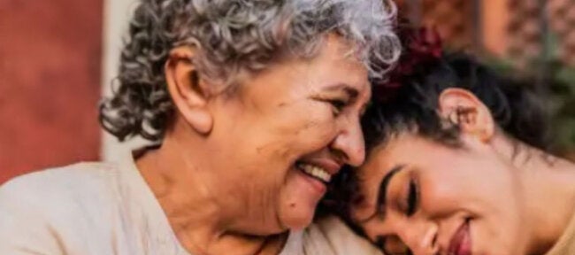 Older adult embraced by family member