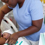 Nurse aids new mom with breastfeeding