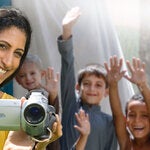 Woman with camera and children behind her