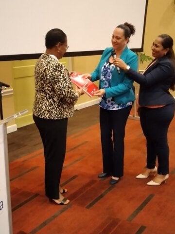 Dr. Karen Lewis-Bell PAHO/WHO Reprecentative in Suriname  receives a copy of the national cancer control plan from Cleopatra  Jessurun the director of the Ministry of Health.