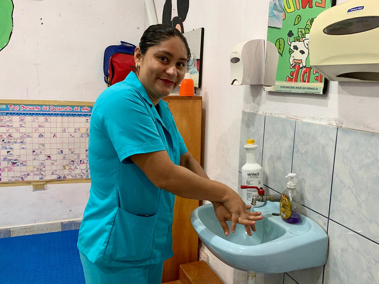 Trabajadora de salud lava sus manos antes de trabajar