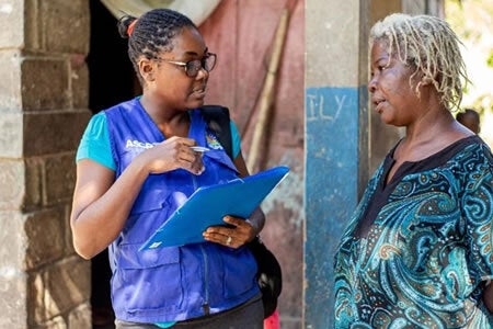 Healthcare worker speaking to elderly woman