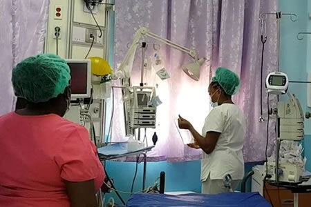 Nurses in a hospital check the flow in an IV tube