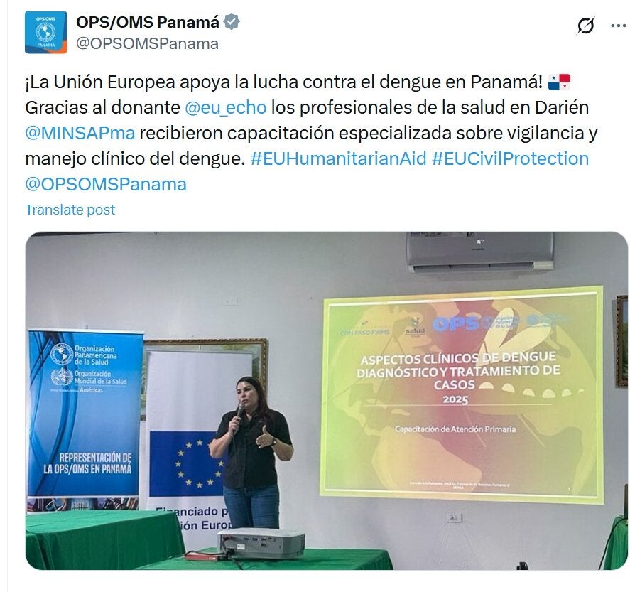 Mujer hablando con micrófono. Detrás se observan banners con logo de la OPS y de la Unión Europea. Se observa pantalla con título del evento. Evento sobre manejo clínico y vingilancia del dengue en Panamá