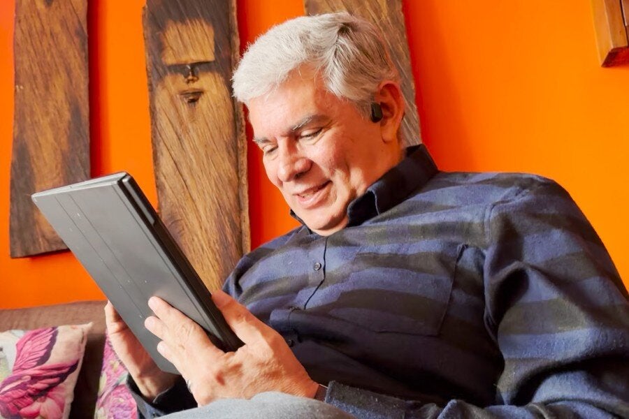 ricardo smiling while viewing a tablet