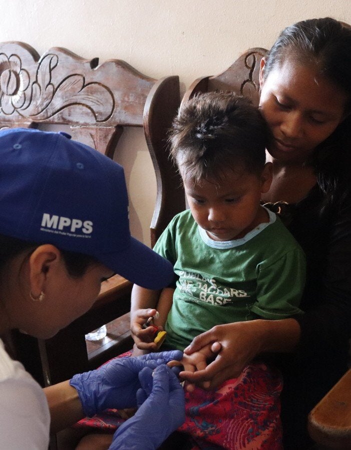 mother holding child receiving blood test