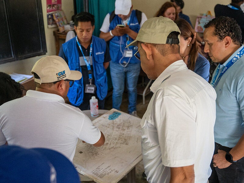 health workers stand around a table and study a map