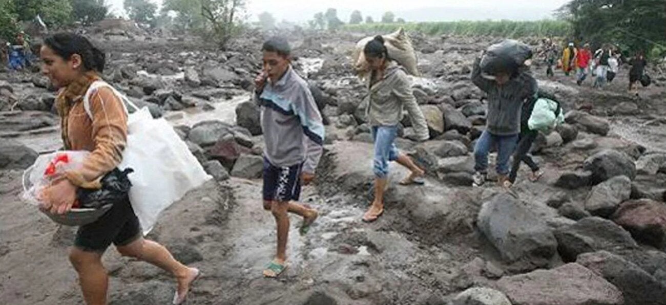 "People crossing a river carrying sacks and belongings