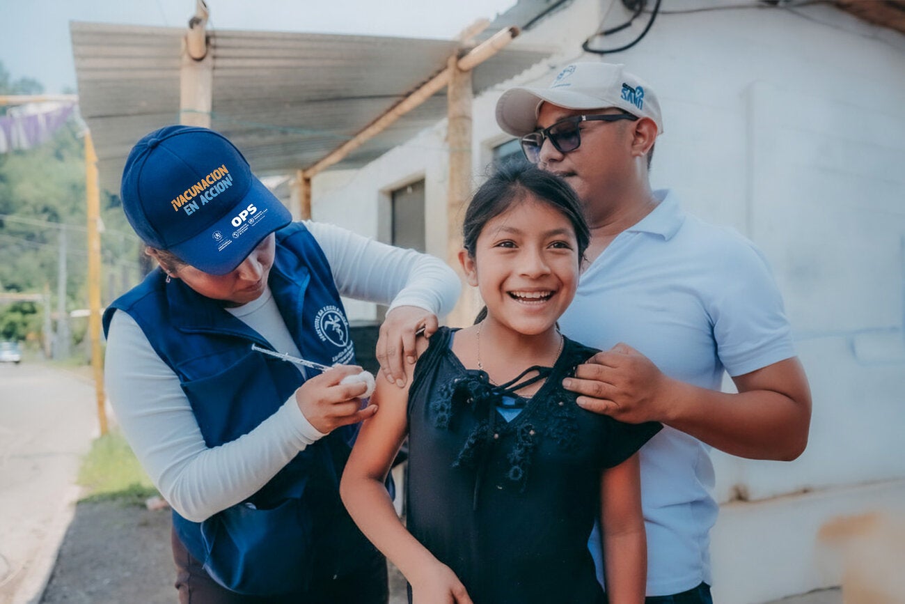 personal de la salud vacuna a una niña sonriente