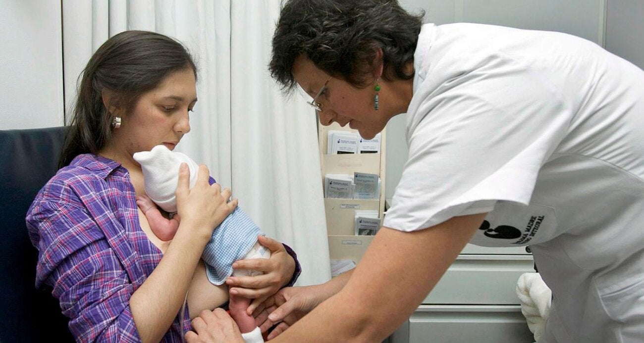 mama con su bebe en una clinica recibiendo apoyo de un medico 