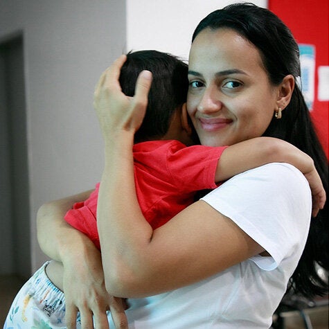 mother hugging her toddler and smiling