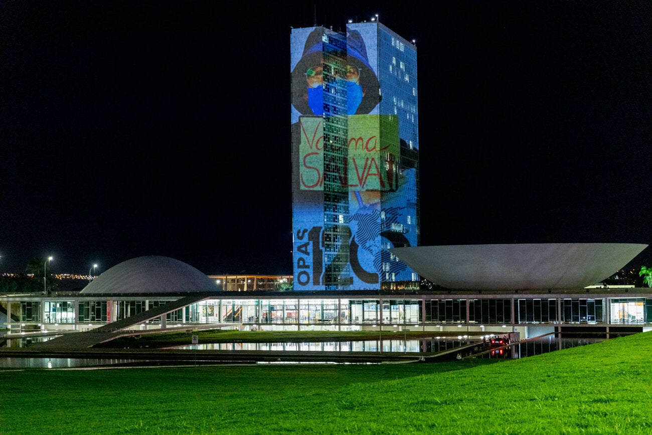 Projeção da imagem de uma criança com a placa Vacina Mais