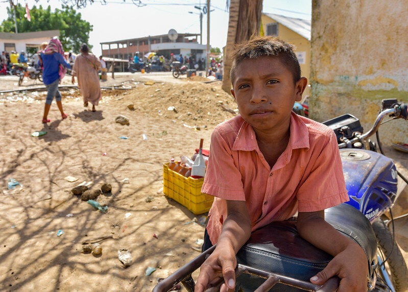 nino acunclillado en la calle