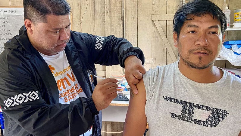 Brazilian man getting vaccinated by indigenous nurse