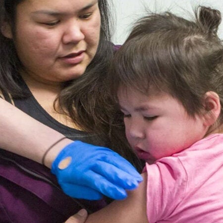 Niña con su madre recibiendo una vacuna