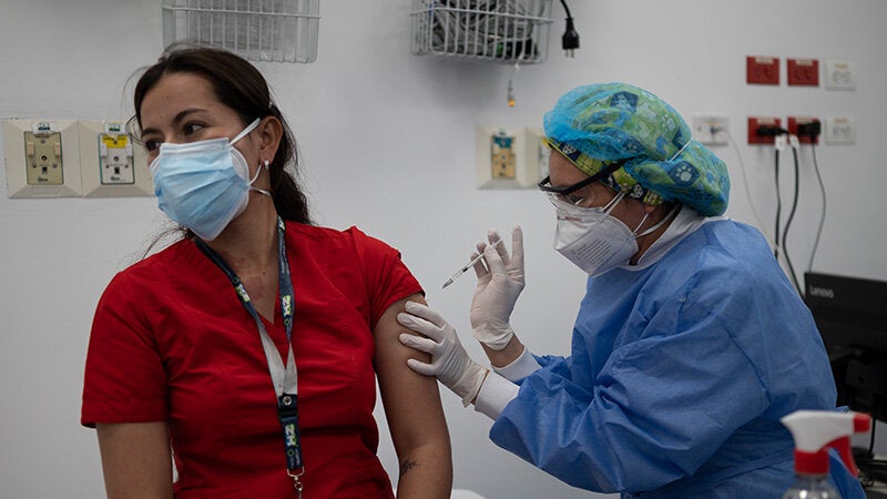 Mujer trabajadora de salud recibiendo vacuna