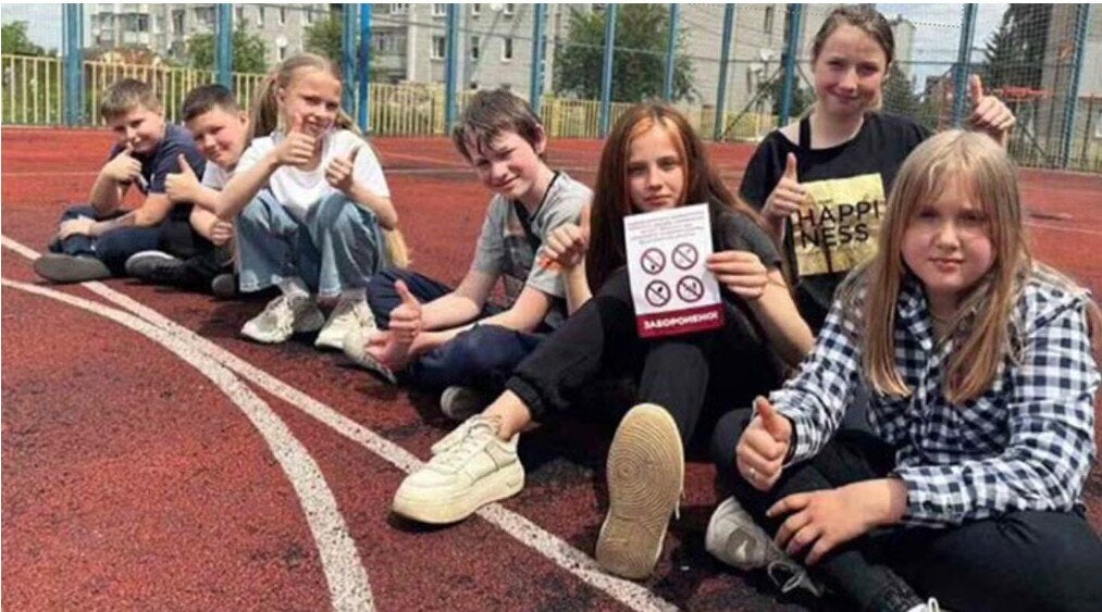 group of children showing printed information against tobacco use
