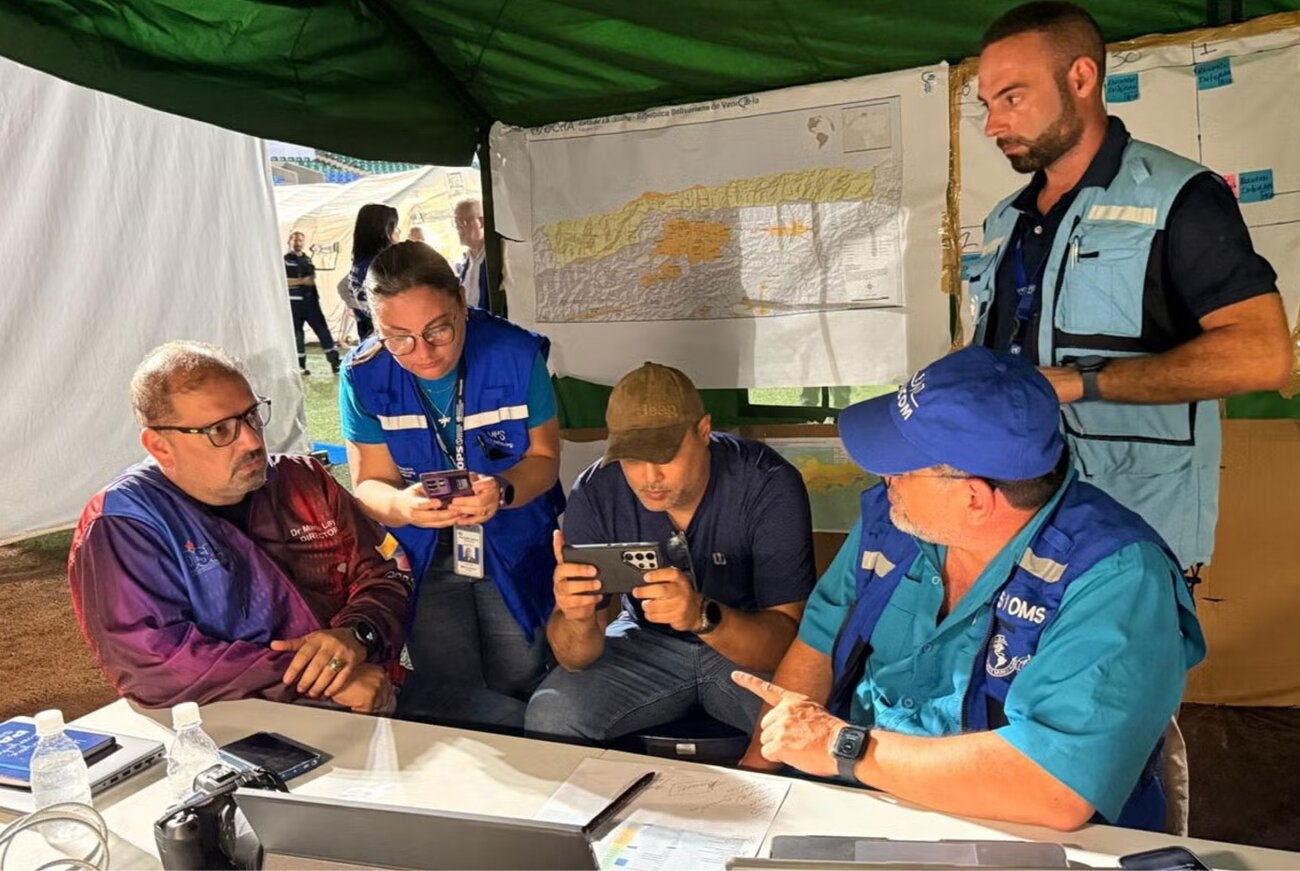 Reunión de consultores para seguimiento de despliegue de EMTs, en carpa.