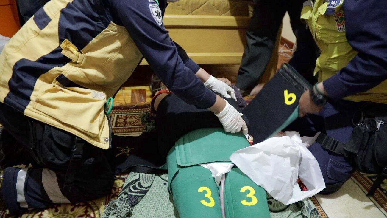 A team from the Ambulance Service for Urgent and Medical Emergencies (SUMA) of El Alto attends a patient