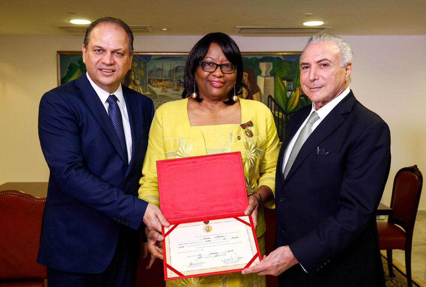 Michel Temer and Ricardo Barros present the Oswaldo Cruz Medal of Merit to Carissa F. Etienne.