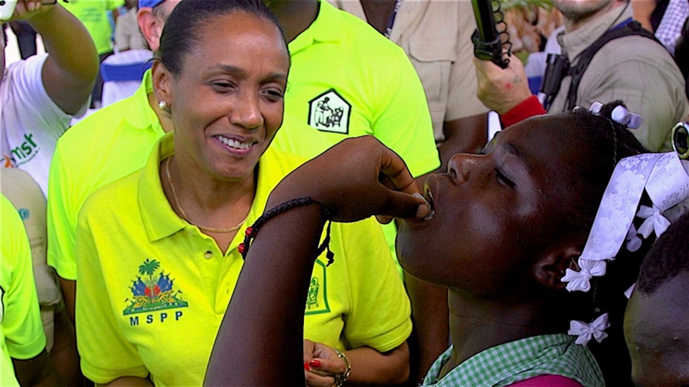 Photo:  PAHO/WHO, D. Spitz. Minister of Health of Haiti, Daphnée Benoit Delsoin, applies the first dose of the oral vaccine of cholera to a student in Les Cayes, Haiti.