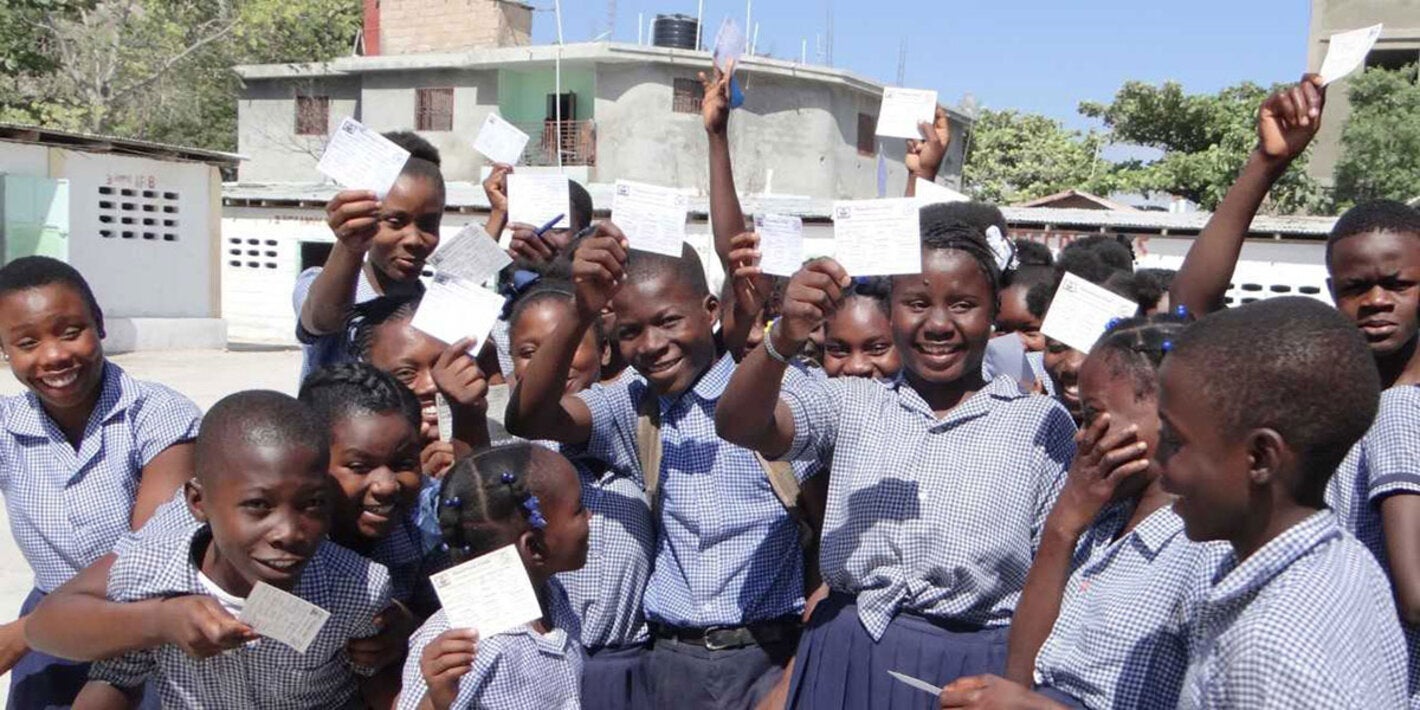 children holding up their vaccination cards