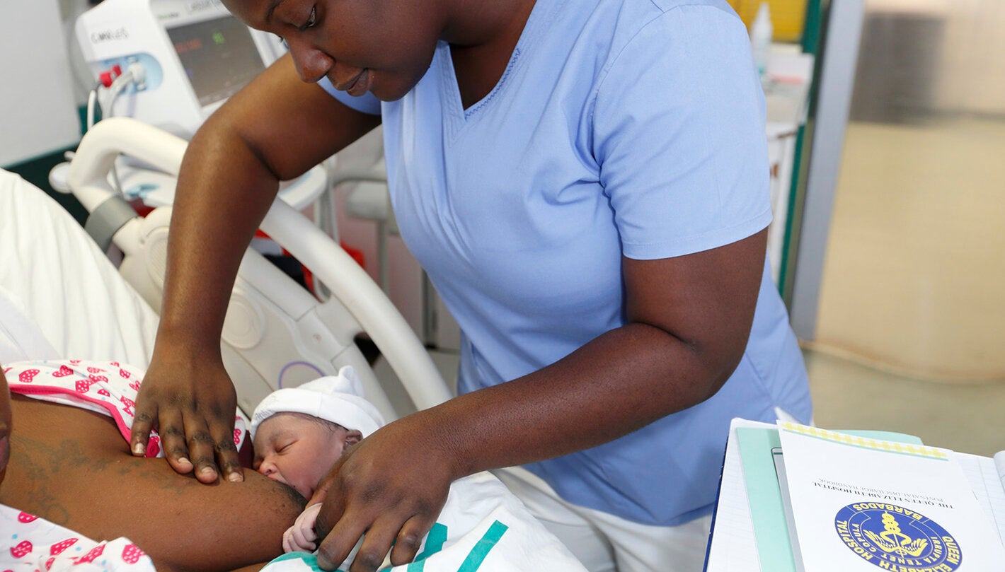 Nurse aids new mom with breastfeeding
