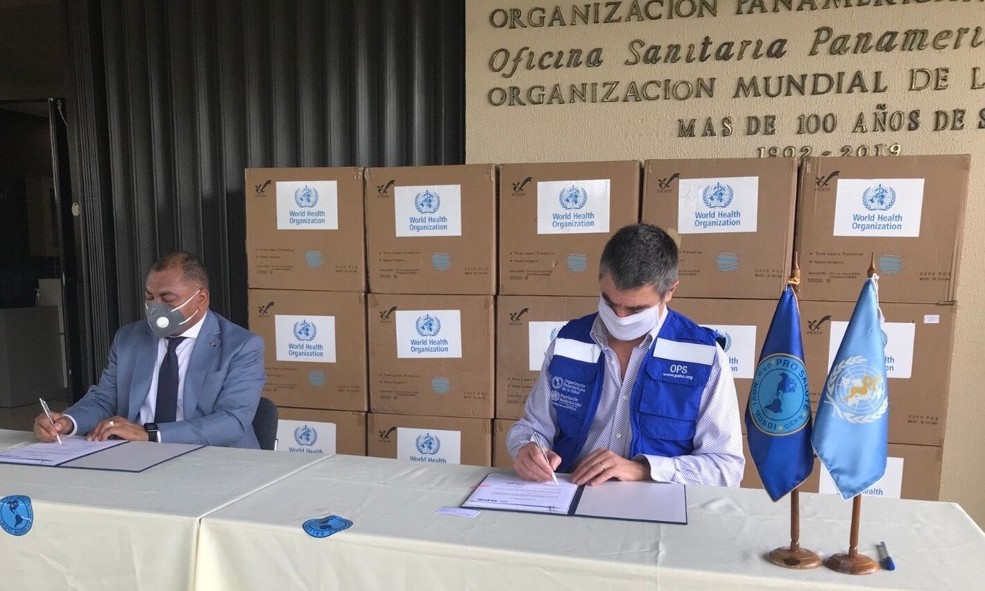 Representante de OPS y autoridad local durante entrega de las mascarillas