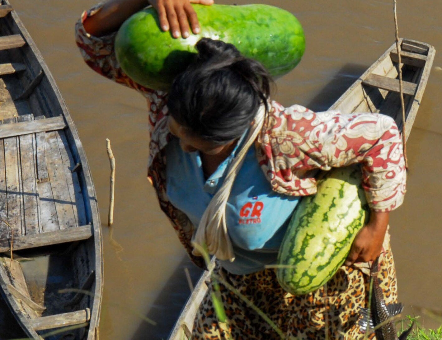 Woman with watermelons and fish in hand