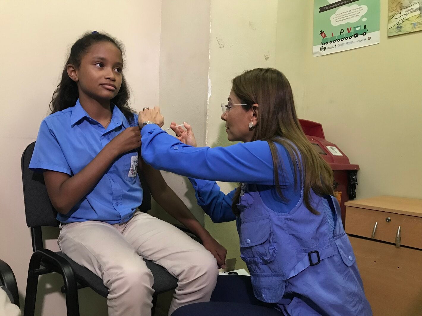 Representante vacuna a una asistente