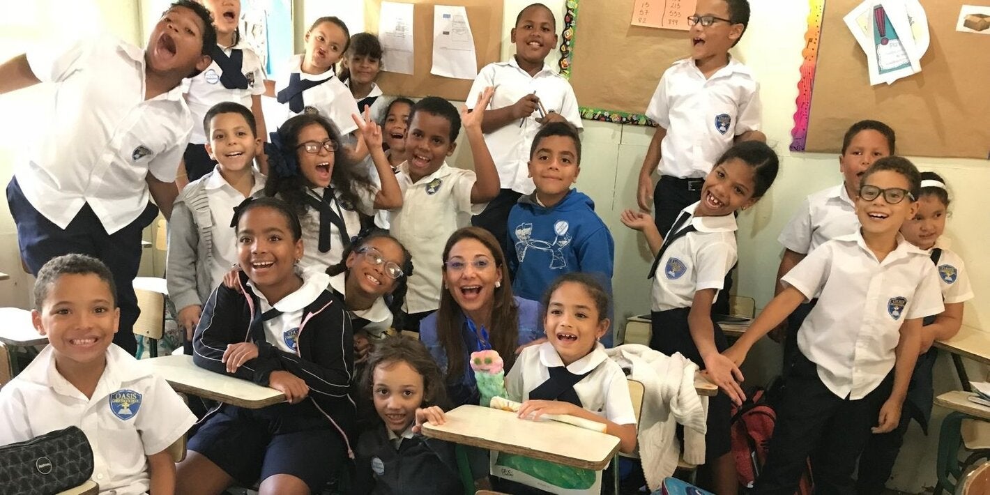 Representante junto a estudiantes de una escuela 