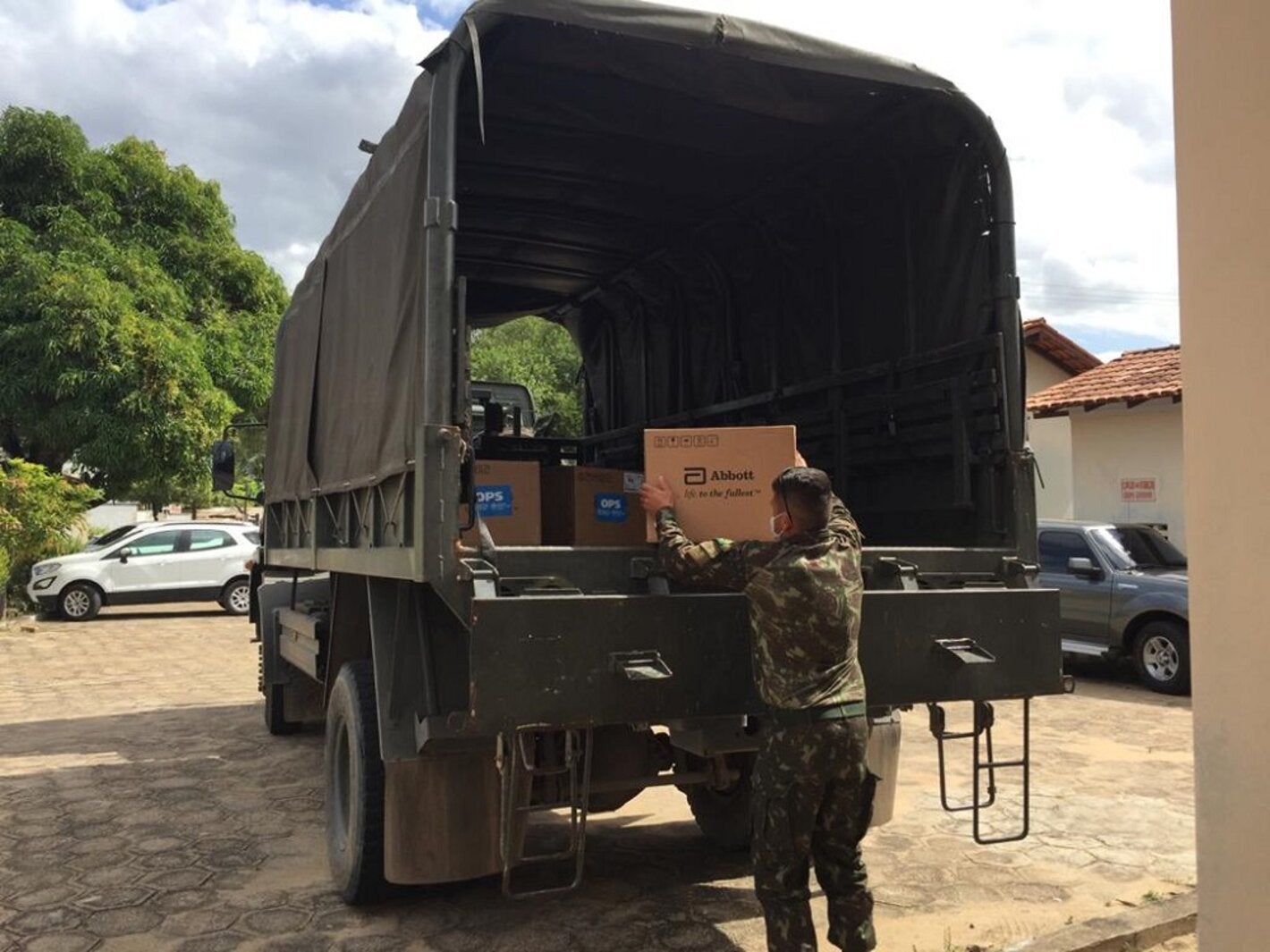 Militares da Força Tarefa da Operação Acolhida, no Brasil, carregam testes para diagnóstico de COVID-19 doados pela OPAS