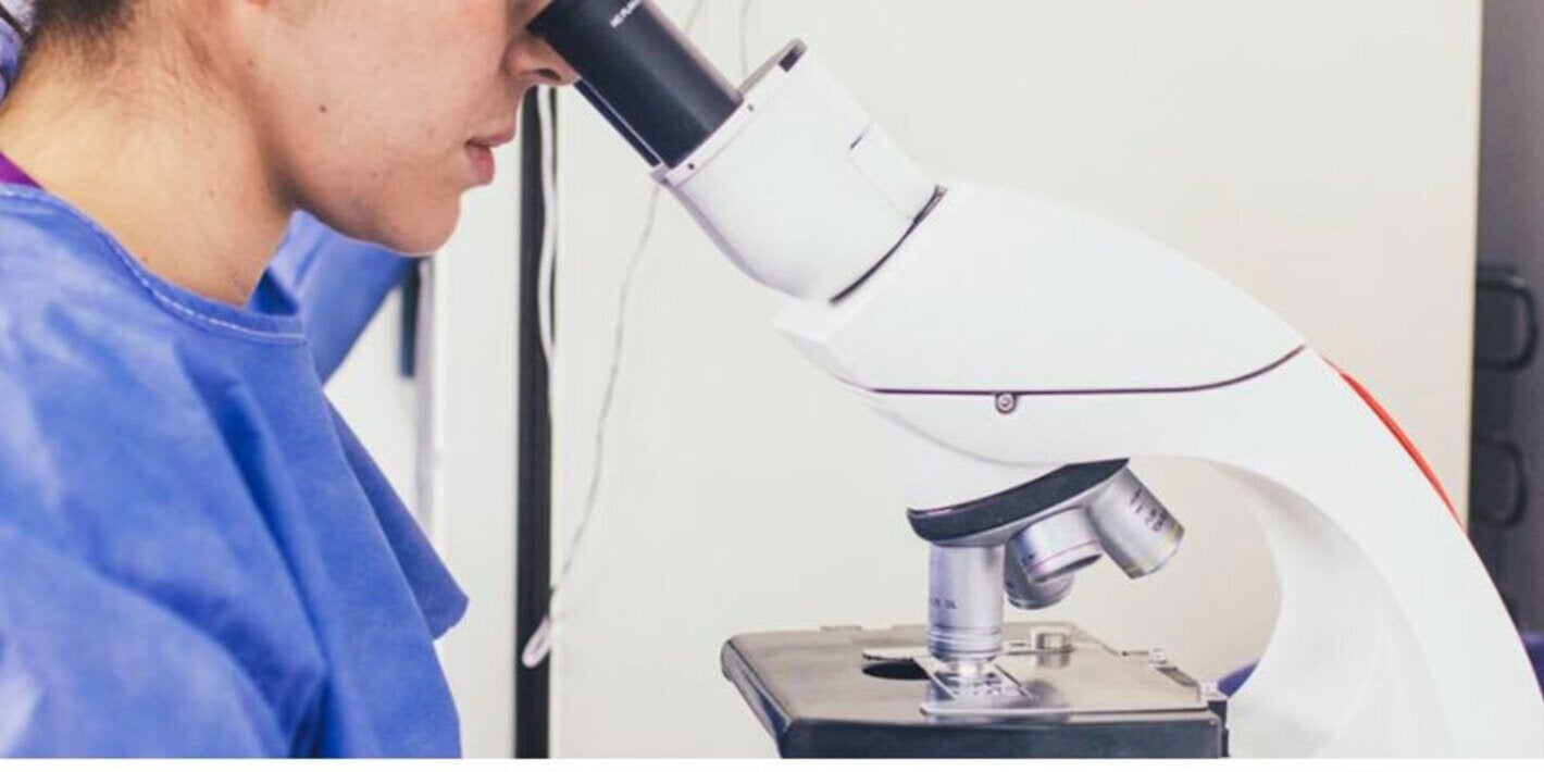 Personal de la salud viendo por un microscopio