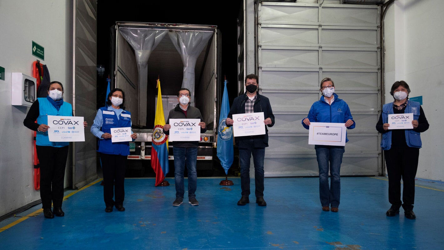 Personal de Entrega de Vacunas con letreros de COVAX