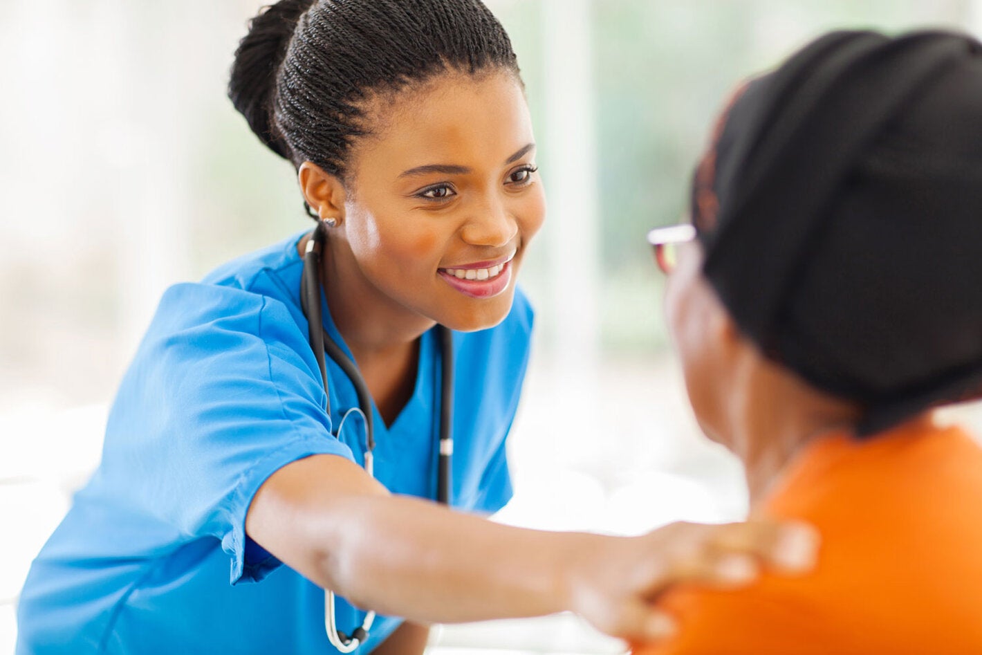 Nurse reaching out to comfort older patient