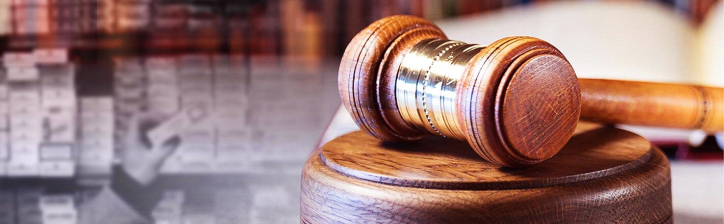 Resting gavel with cigarette packaging in the background