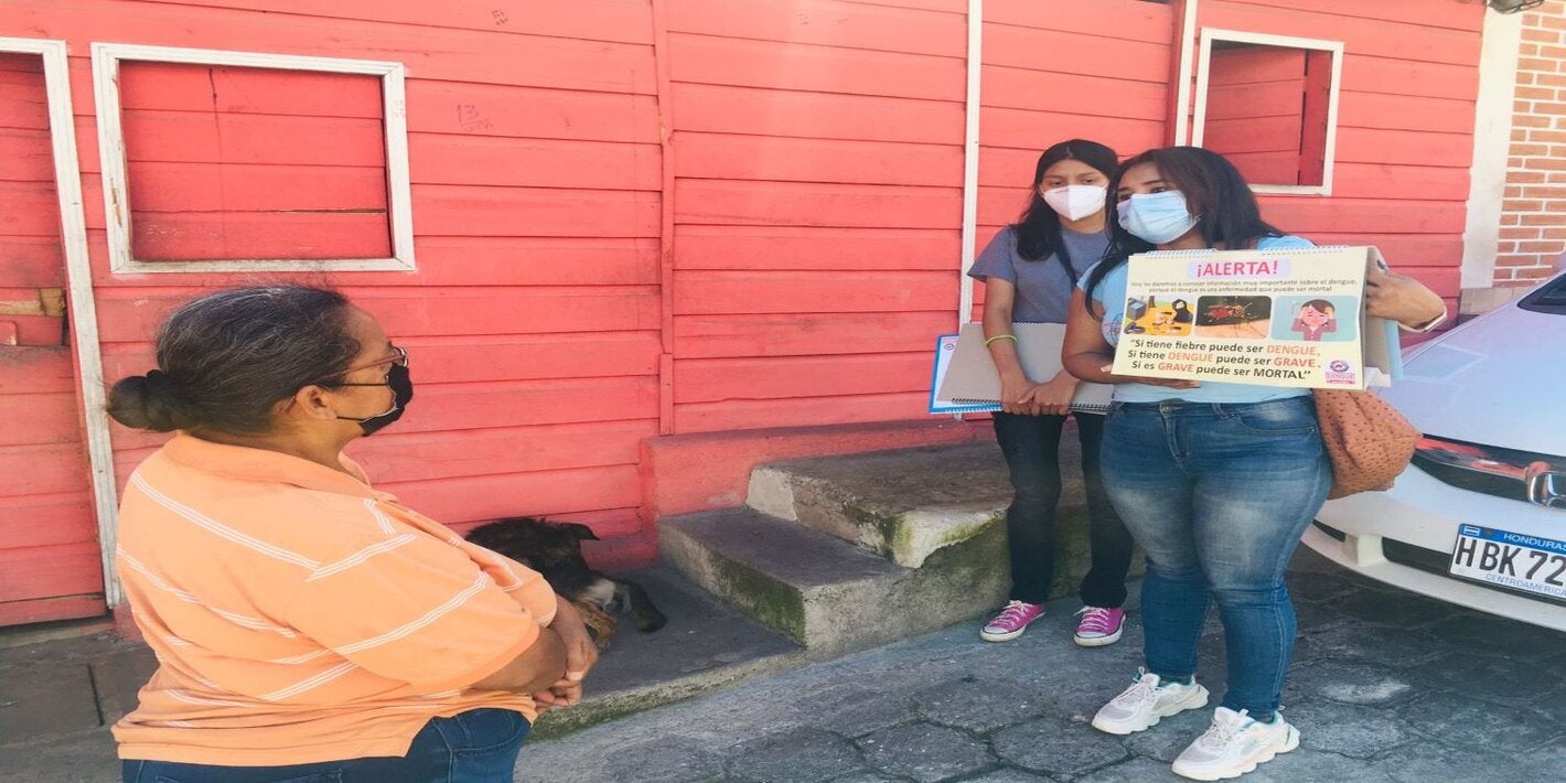 jóvenes promotores de salud, hablando en la comunidad sobre prevención del dengue y La COVID-19, usando rotafolio