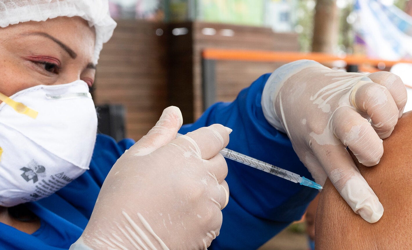 Health worker applies COVID-19 vaccine