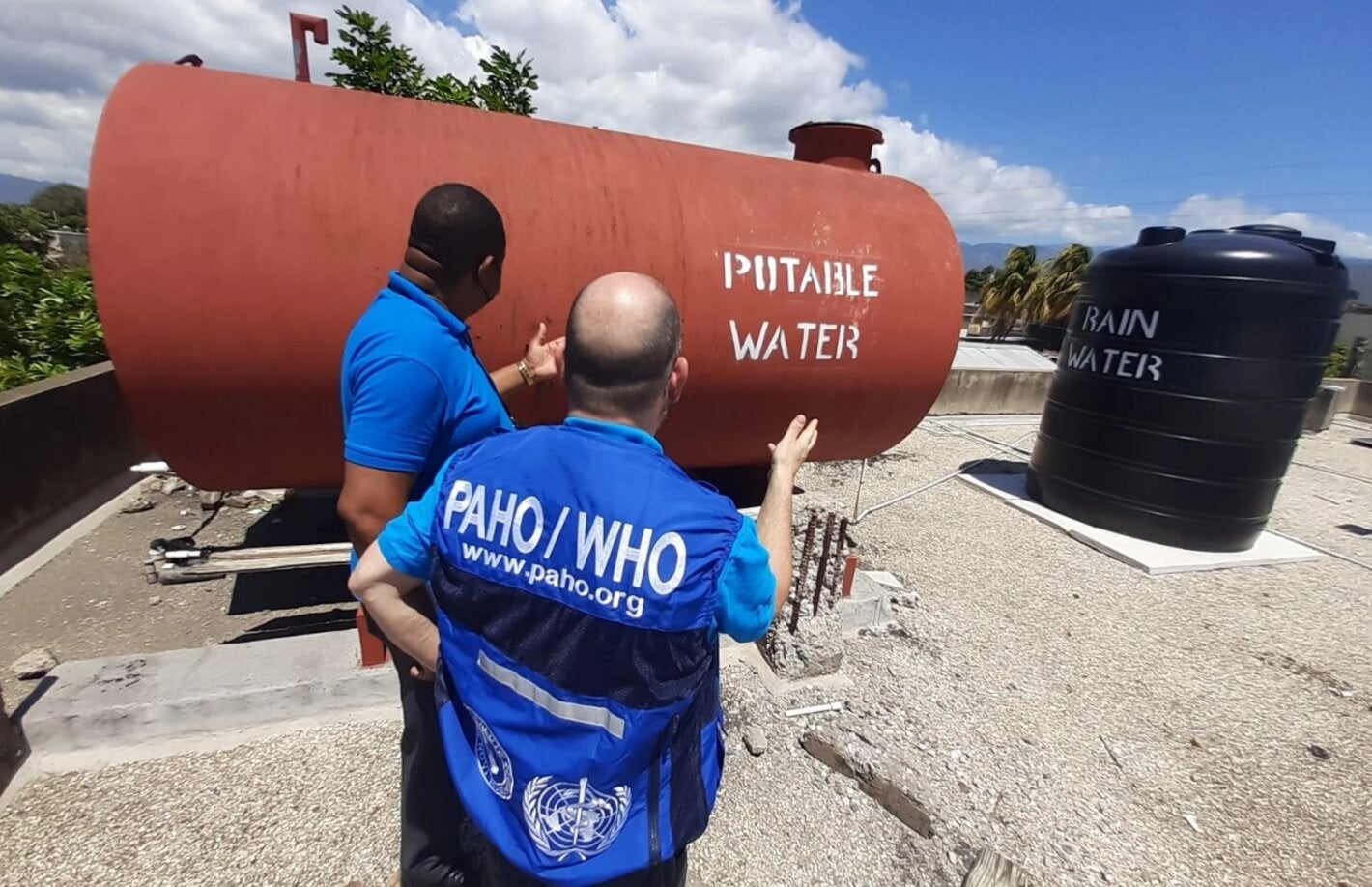 Representatives from the Pan American Health Organization/ World Health Organization Country Office in Jamaica view rainwater and potable water tanks on the roof of the Denham Town Health Centre