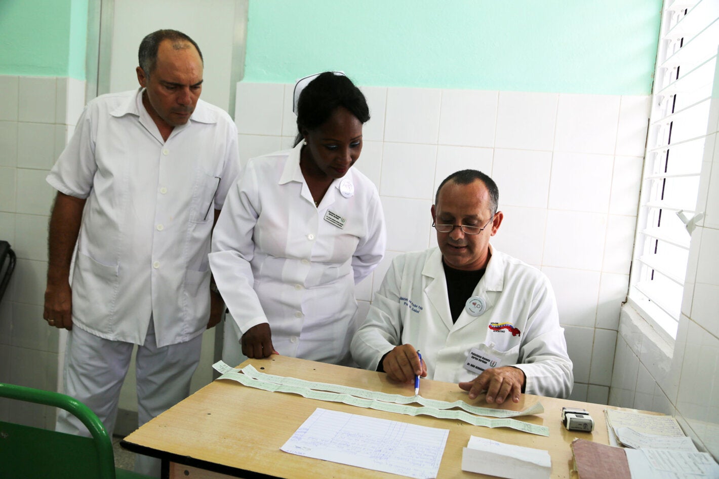 El doctor Iván Hernández Cruz comenta con el equipo de salud de la urgencia del Policlínico Verdugo, el electrocardiograma que le realizaron a una paciente que llegó con una crisis hipertensiva.