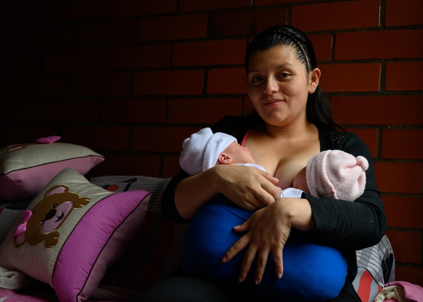 Mulher amamentando dois bebês