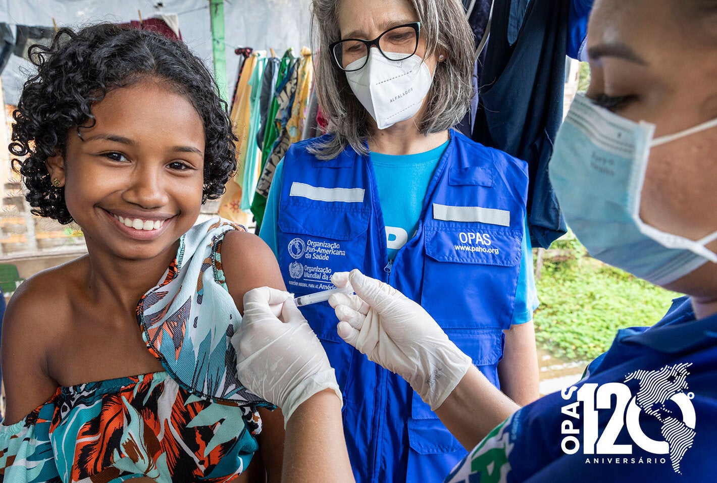 Criança sorrindo recebendo a vacina
