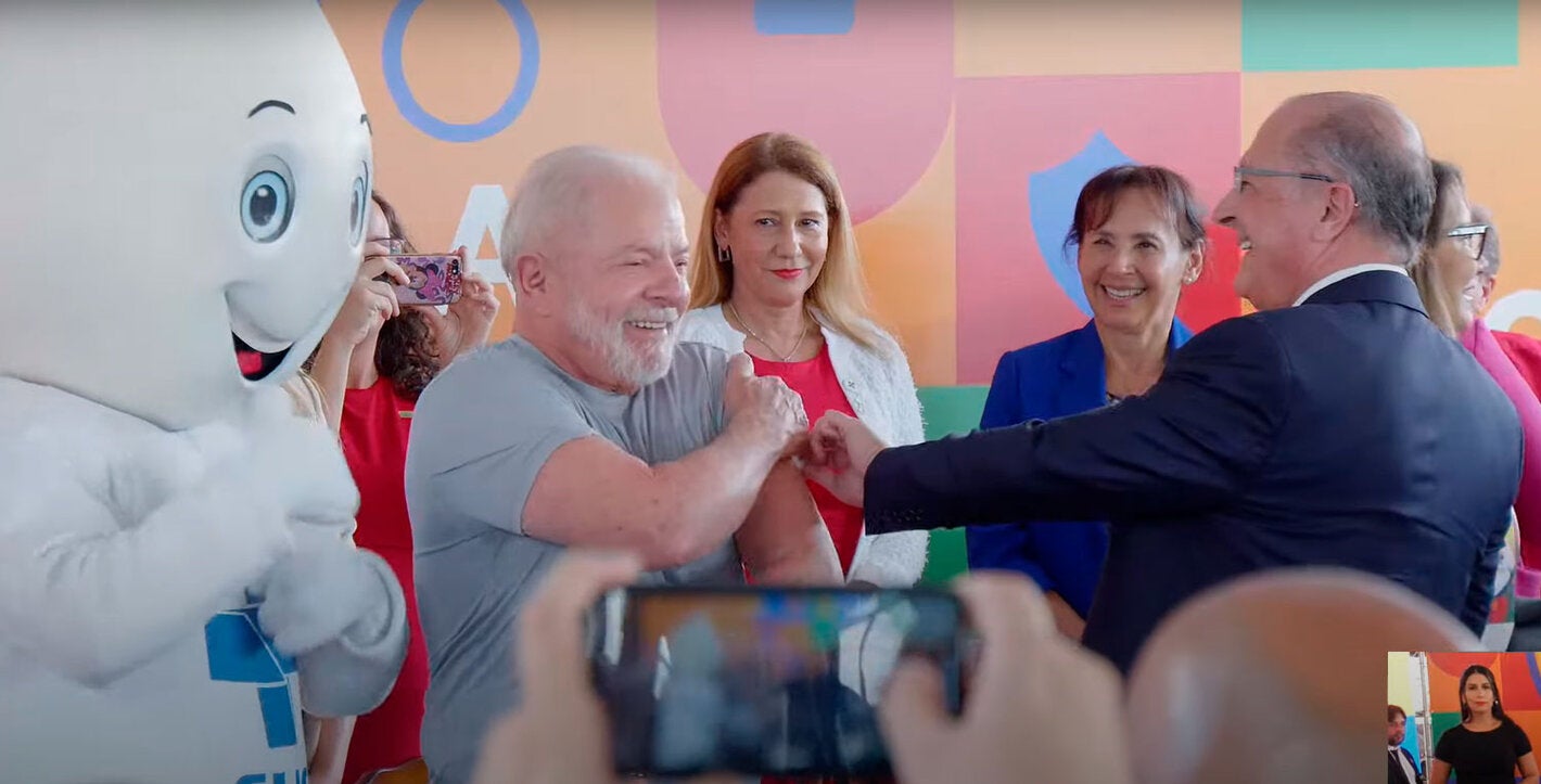 Presidente do Brasil recebe a vacina do vice-presidente, dra. Socorro Gross está entre os dois ao fundo