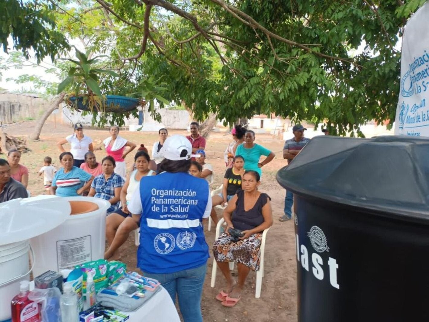 personal de OPS entregando filtros y tanques  de agua a comunidad