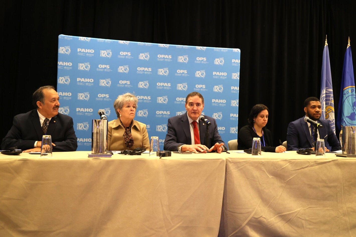 Grupo de autoridades de salud en mesa principal